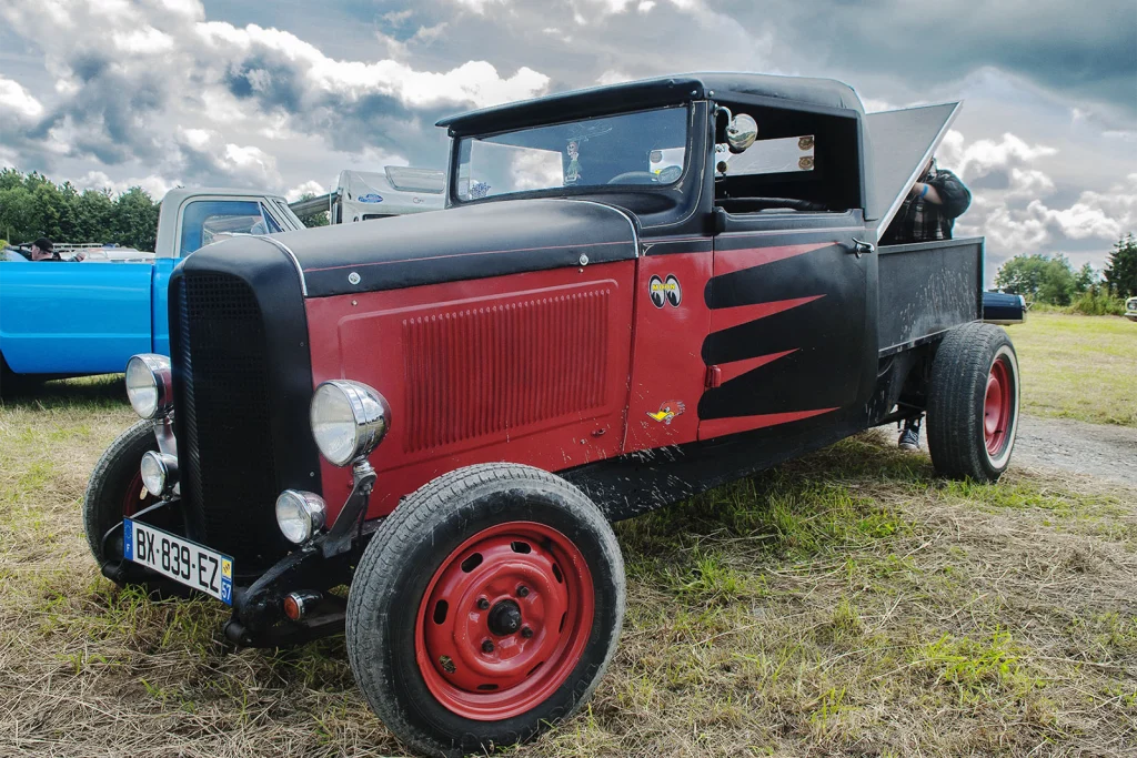 Hot rod noir et rouge aux jantes rouges sur l'herbe au Hot Rod Custom Show de Chimay