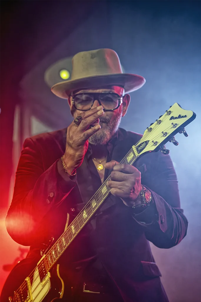 Barry Adamson à la guitare électrique dans une lumière rouge et bleue, BXL Central, Bruxelles. Photo Didier Vaneesbeck