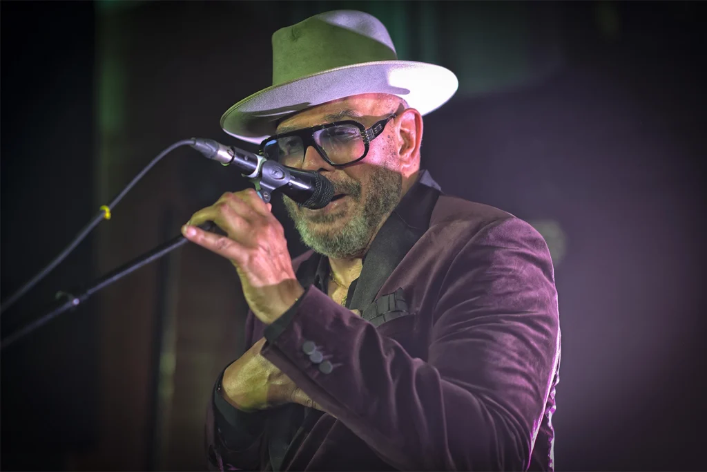 Barry Adamson au micro dans une lumière verte et violette, concert BXL Central chez PIAS. Photo Didier Vaneesbeck