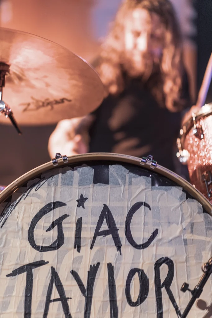 La grosse caisse peinte au nom de Giac Taylor, le batteur en arrière-plan, Brasserie Illegaal. Photo Didier Vaneesbeck