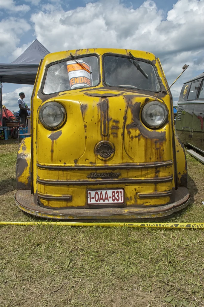 Avant d'une voiture ancienne jaune patinée au Hot Rod Custom Show de Chimay