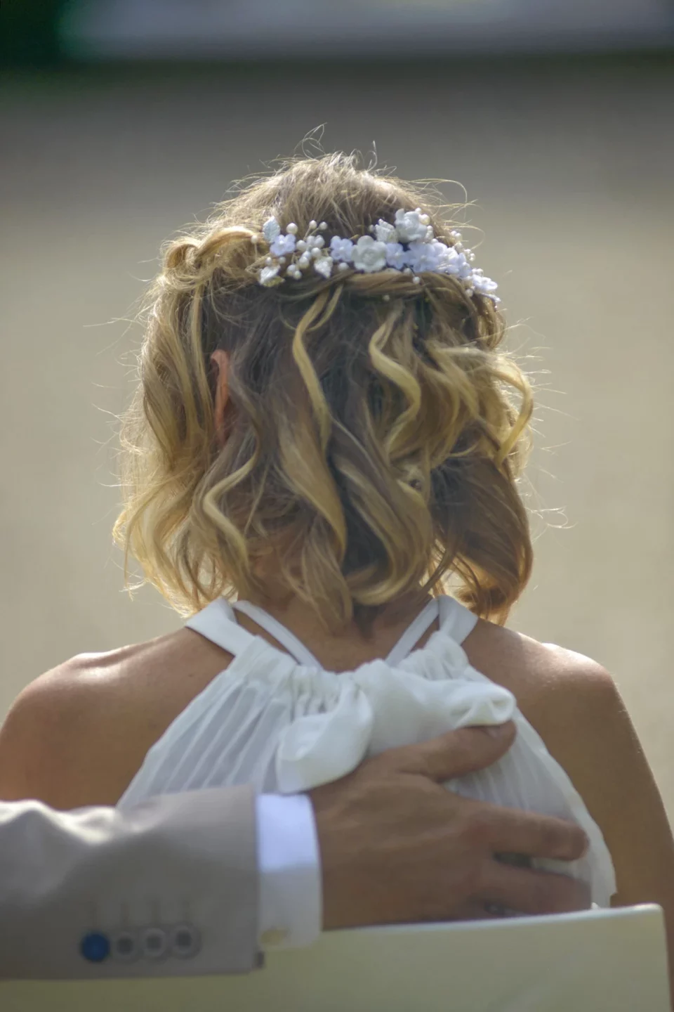 Petite demoiselle d'honneur de dos, couronne de fleurs dans les cheveux