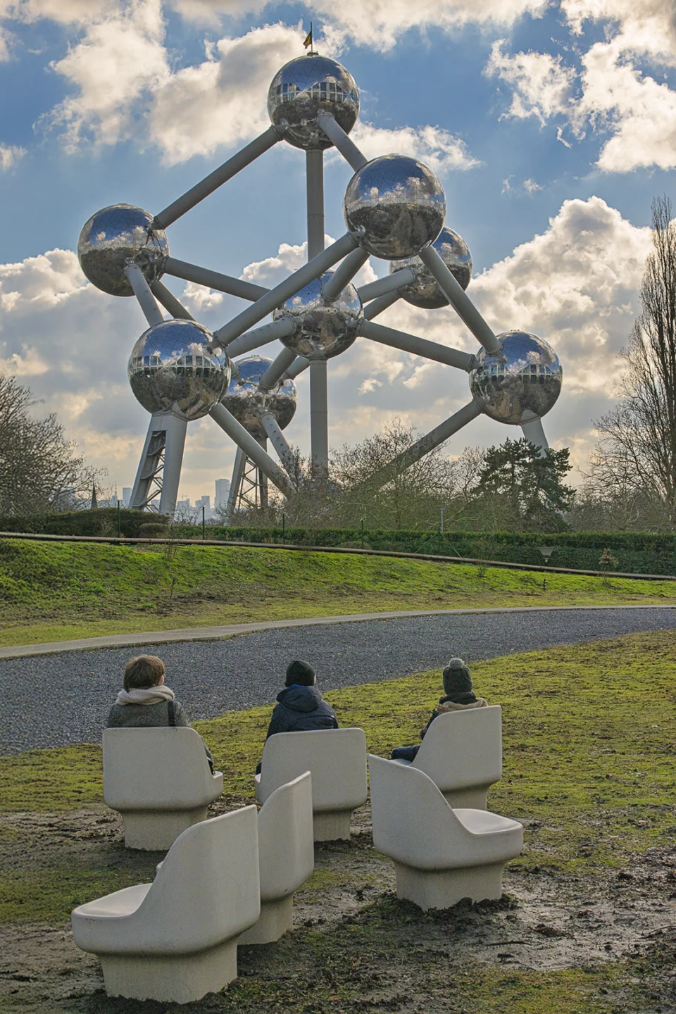 L'Atomium à Bruxelles, promeneurs assis sur des bancs au premier plan