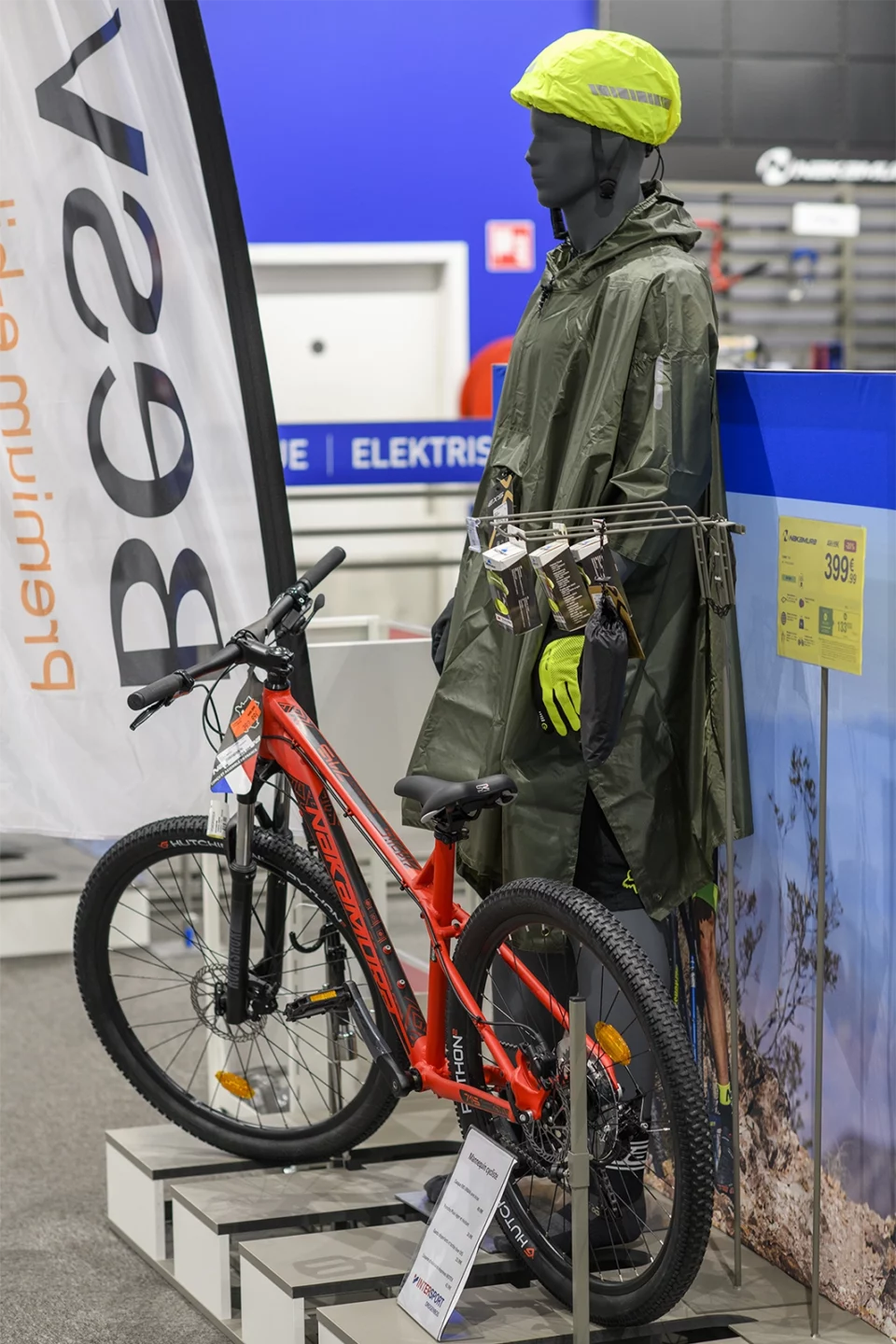 Vélo électrique et mannequin en tenue de pluie sur un stand de salon