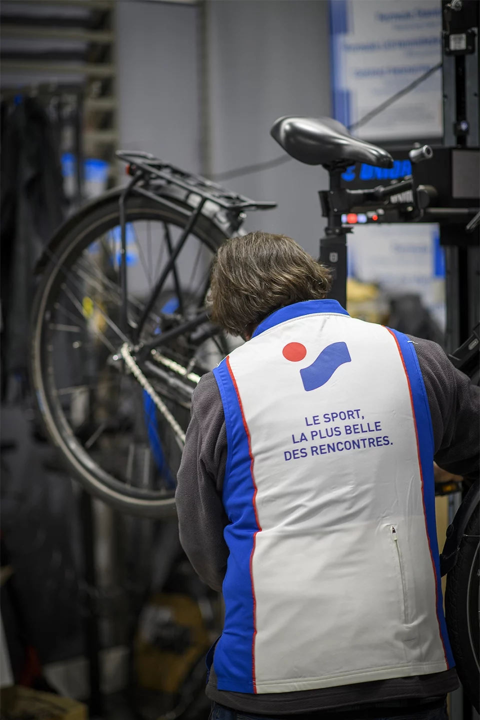 Mécanicien de dos, réparant un vélo dans son atelier