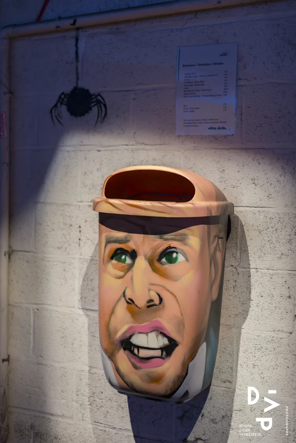 Masque sculpté d'un visage coiffé d'un bonnet, éclairé dans la pénombre – Strokar Inside, Bruxelles 2018