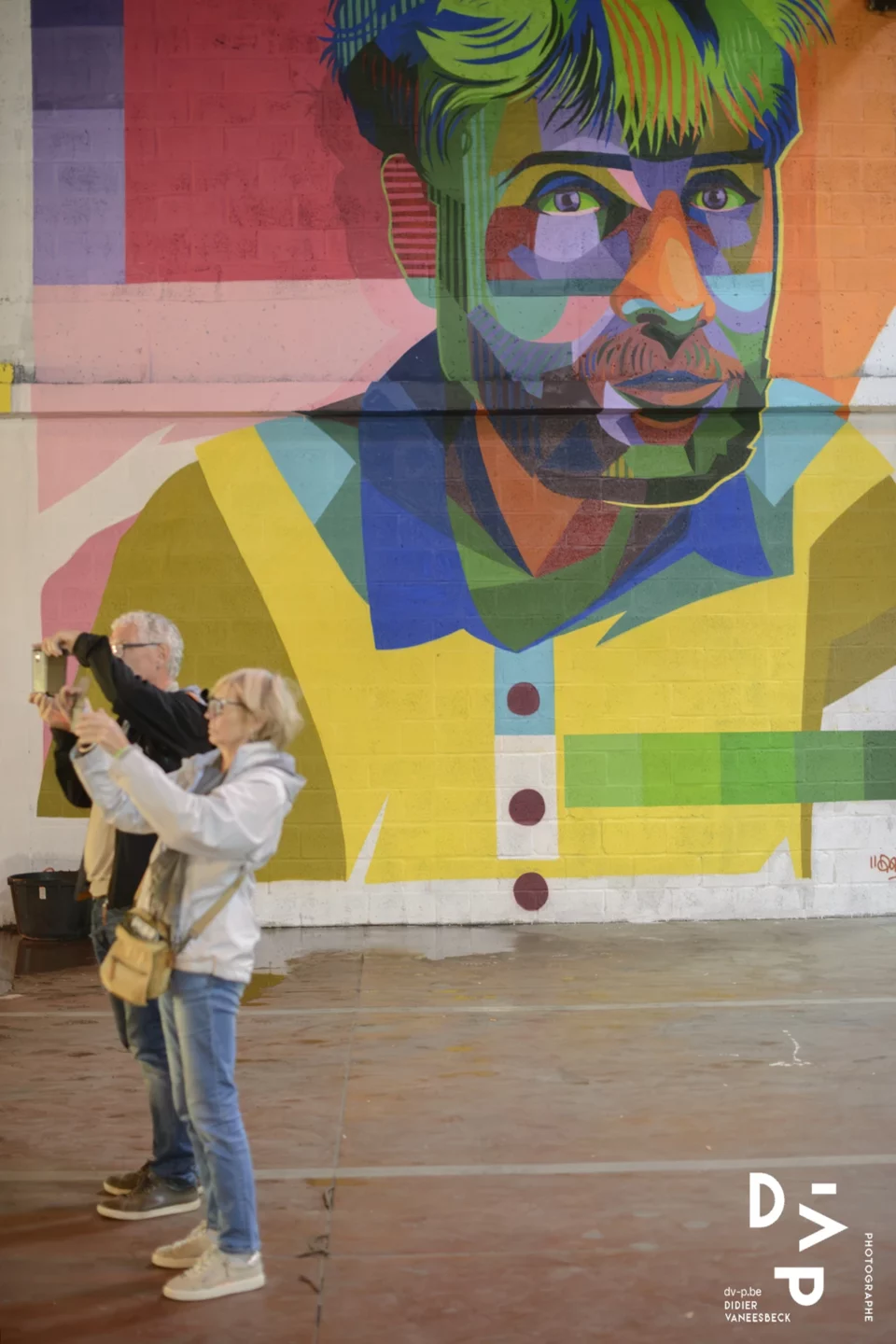 Visiteur photographiant une fresque de personnage coloré – Strokar Inside, Bruxelles 2018